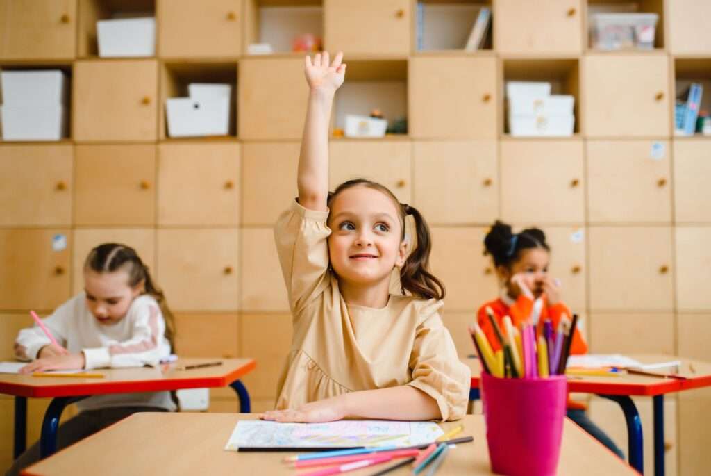 girl raising her hand in class