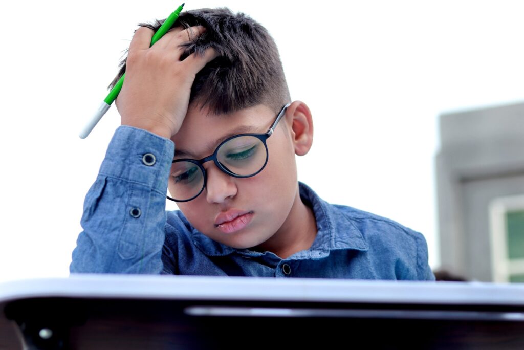 student with his head in his hand looking frustrated