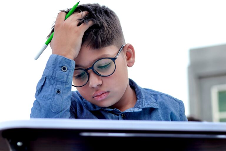 student with his head in his hand looking frustrated