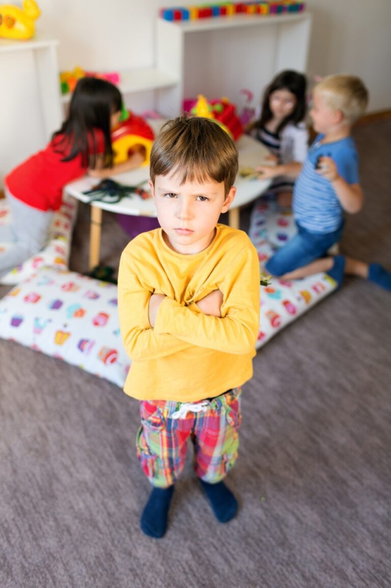 grumpy child with other children playing behind them
