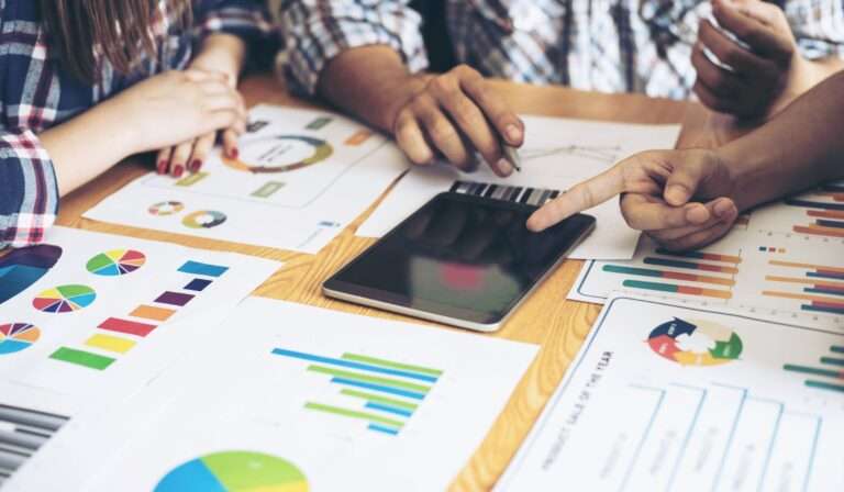 a group of people around a table looking at beahvior data graphs