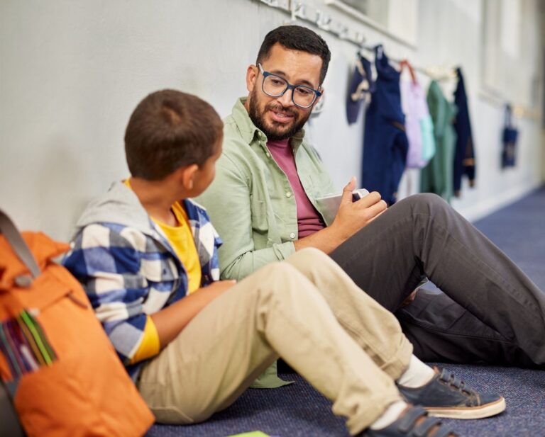 adult and student talking in hallway