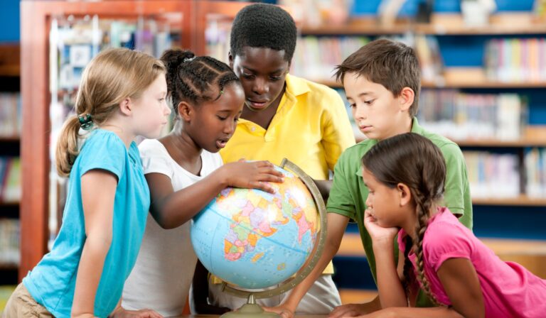 children looking at a globe