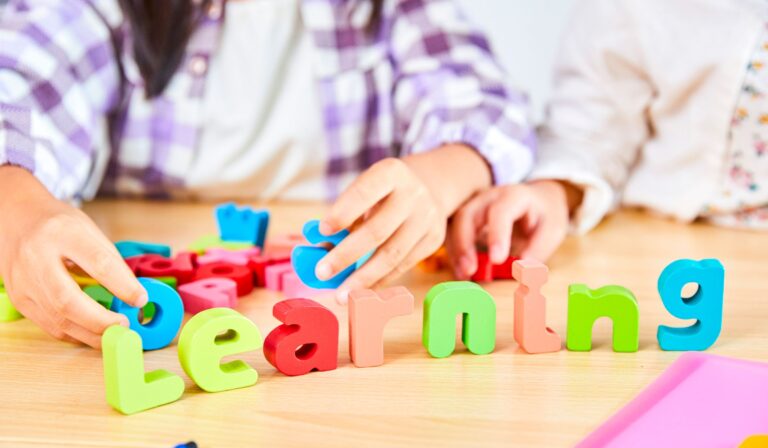 children spelling "learning" with blocks