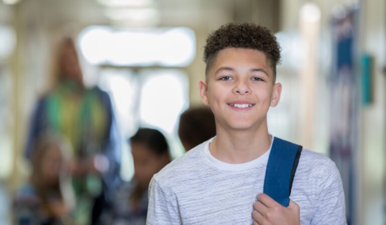middle school student boy standing in school hallway