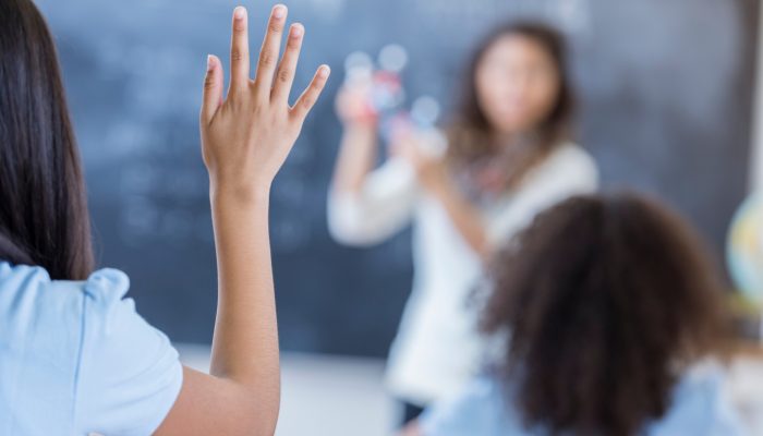 student raising hand in class