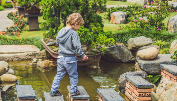 bridge the gap - child using stones to cross water