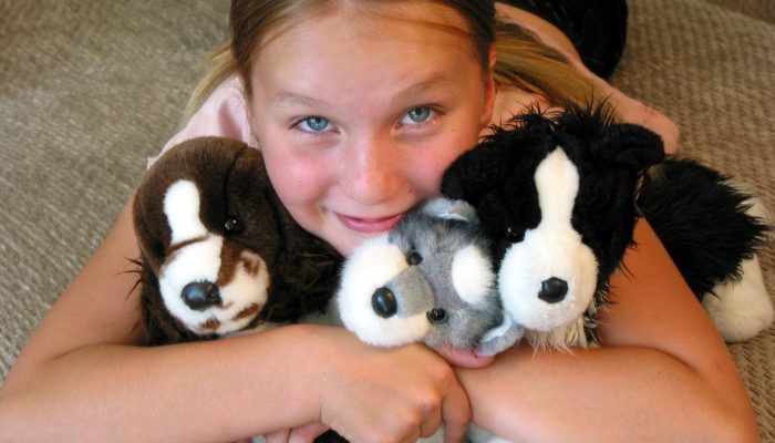 child hugging stuffed animals