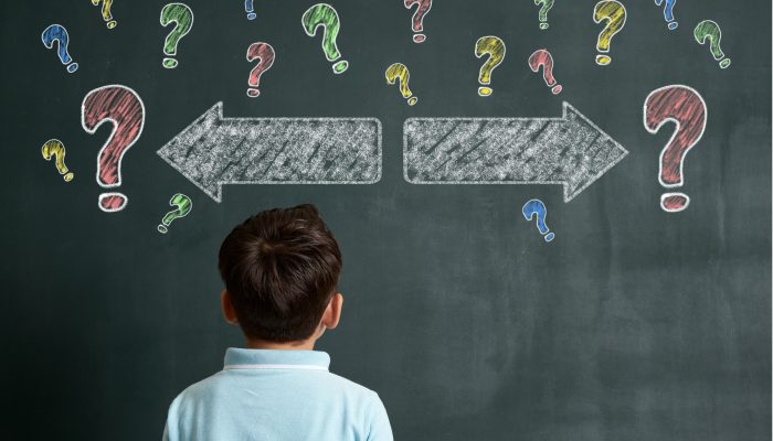 allow children to make choices - boy looking at chalkboard with question marks and arrows pointing both left and right