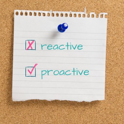 reactive vs proactive written on a note stuck to a cork board