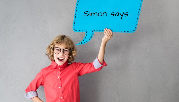 boy holding large dialog box that says "Simon says"